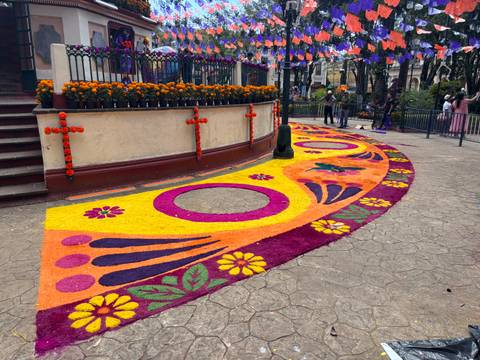 Colorful sidewalk decoration with flowers and crosses.