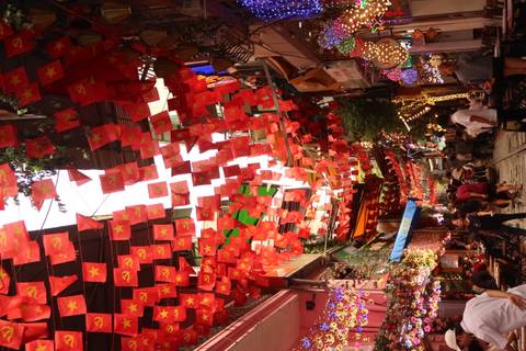       Bustling street with decorative banners and pedestrians.
  