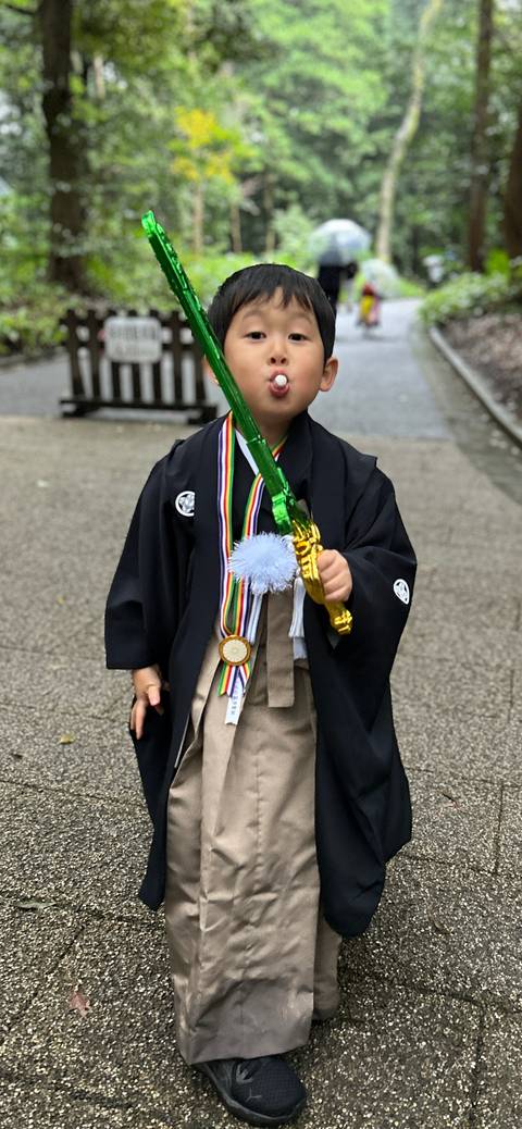 A child dressed in traditional Japanese clothing holding a toy sword.