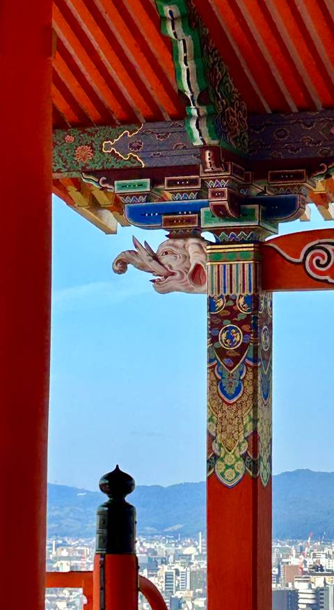       Detailed view of an intricately carved wooden column with elephants.
  