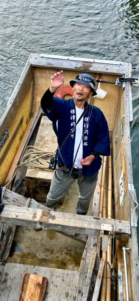       Man on a boat giving a thumbs-up near the water.
  