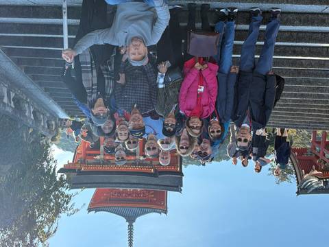       Group of tourists posing on steps with a traditional Japanese shrine in the background.
  