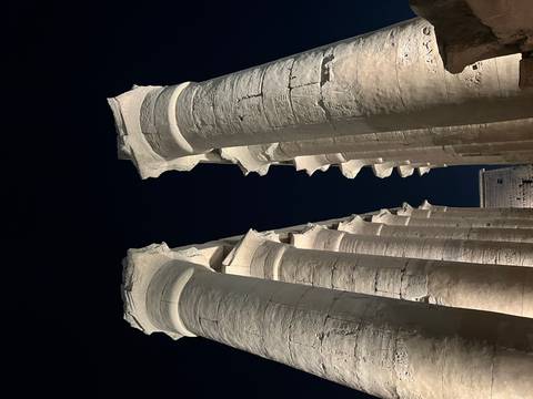 Close-up of ancient columns and ruins at night.