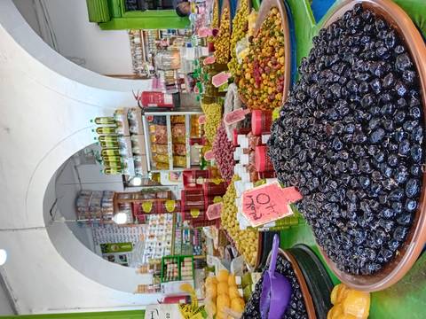 Market stall displaying various olives and products.
