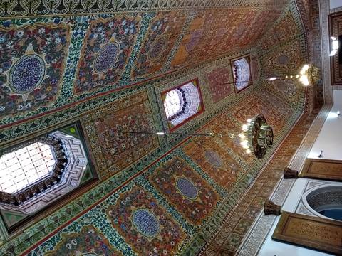       Colorful and ornately decorated ceiling with chandeliers.
  