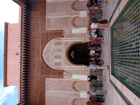 Tourists in front of a beautifully decorated Moroccan building.