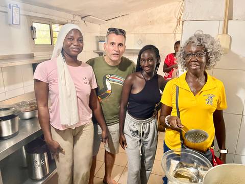 Group of people in a brightly lit kitchen setting.