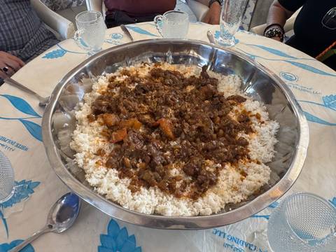 Large serving dish filled with rice and stew on a dining table.