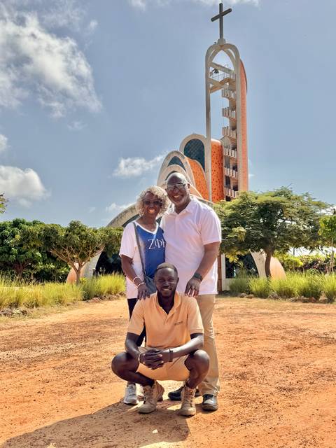 Three people standing in front of a modern architectural structure.