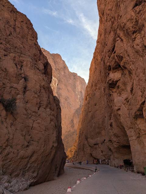 Canyon with tall rocky cliffs under a blue sky.