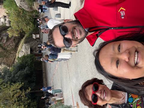 Selfie with several people in a courtyard with trees and stone paths.