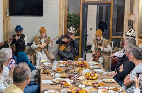 A group of musicians performing traditional music at a dinner table.