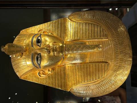       Gold mask of an Egyptian pharaoh with intricate design and features.
  