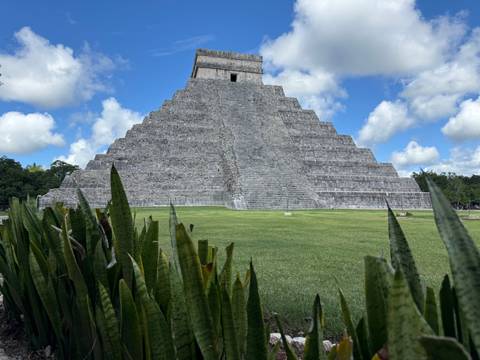Mayan pyramid surrounded by lush greenery.