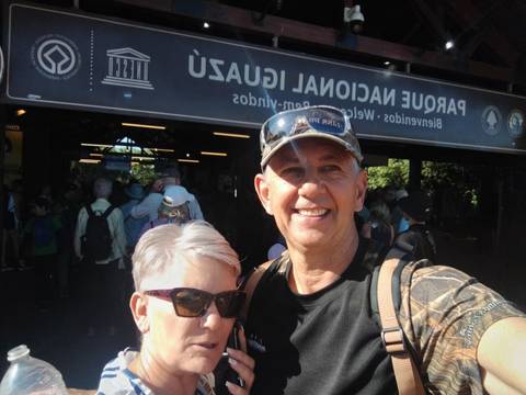       Couple in front of 'Parque Nacional Iguazu' sign.
  