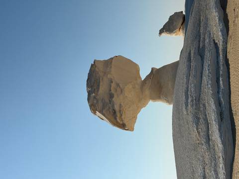 Rock formation resembling a balancing rock in the desert.
