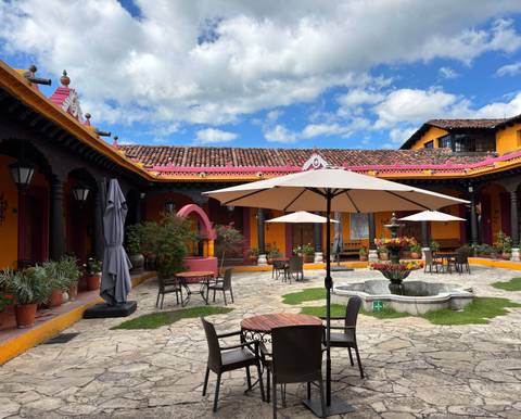 Colorful courtyard with umbrellas and potted plants.