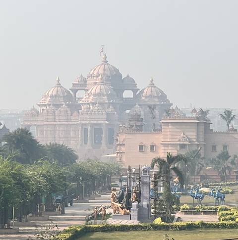       Distant view of a large ornate temple partially obscured by haze.
  