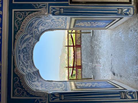       Decorative doorway with a view of distant hills through the arch.
  