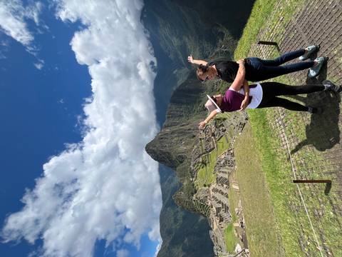 Two people posing with Machu Picchu in the background.