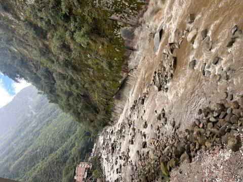 Rocky river with a mountainous and verdant backdrop.