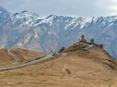 Hilltop church with snowy mountains in the background.