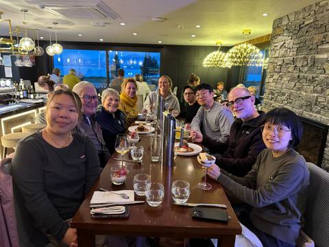 Group of people dining together at a restaurant with views.