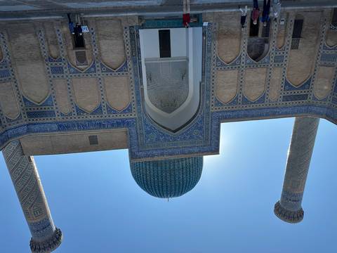       A masjid with striking blue tiles and towers under a blue sky.
  