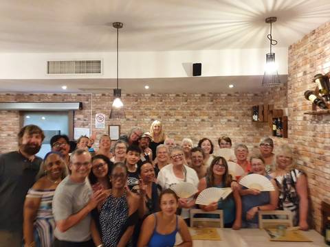 Indoor gathering of a large group of people posing together.
