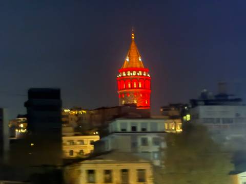 A brightly lit tower over a cityscape at night.