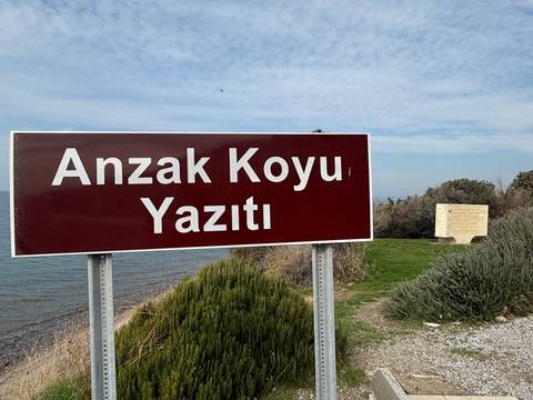 A sign reading 'Anzak Koyu Yazıtı' with a memorial.