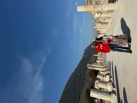       A couple posing with ancient ruins and a blue sky.
  