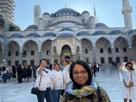       A woman at a historic mosque courtyard.
  
