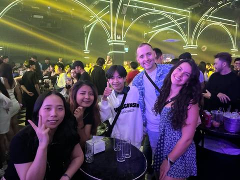       Group posing in a nightclub with bright lights.
  
