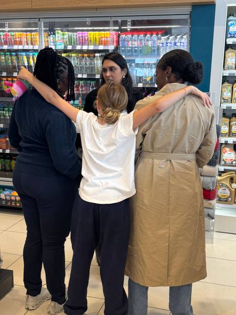       Group of people in a store, facing away from the camera.
  