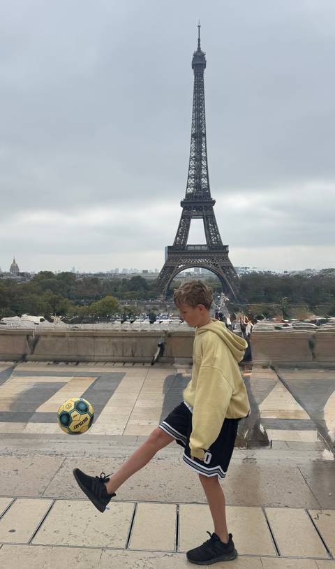A child standing with the Eiffel Tower in the background.