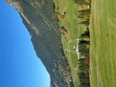 Scenic landscape of hills and trees with a clear sky.