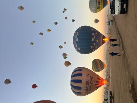 Colorful hot air balloons taking off at sunrise.