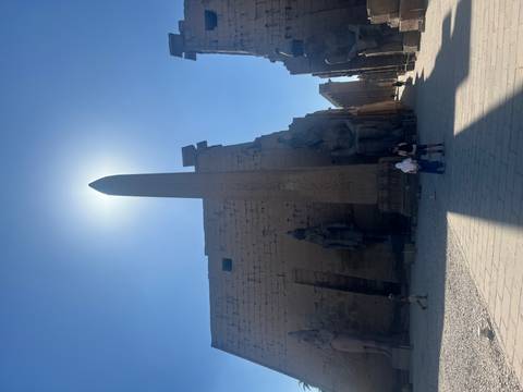 Temple courtyard with a tall obelisk at center.