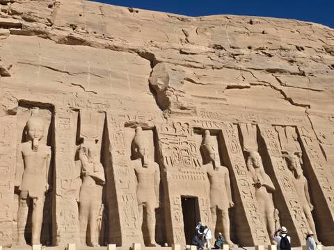       Carved statues on the facade of an ancient rock temple.
  