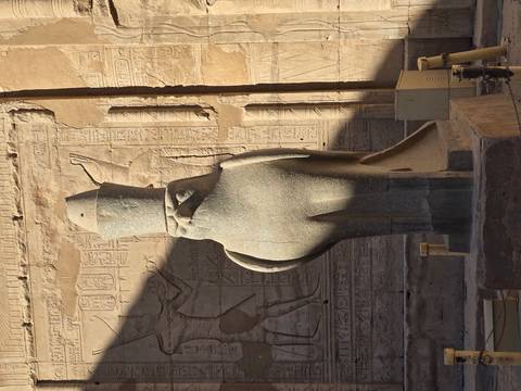 Statue of a falcon in ancient temple surroundings.