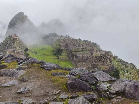       Panoramic view of Machu Picchu partially covered by mist.
  