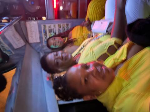 Group of people posing for a photo inside a vehicle.