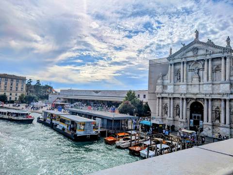 Busy canal scene with boats and a historic church.