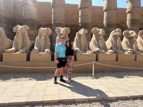      Two people posing at the entrance of the Karnak Temple.
  