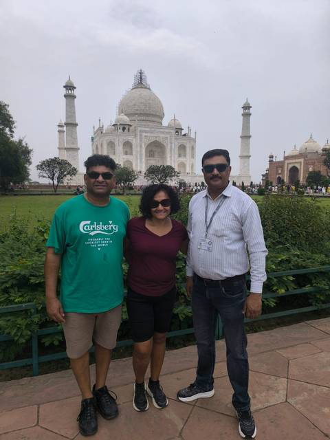       Group of people posing in front of the Taj Mahal.
  