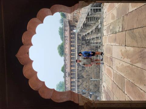 People posing under an archway at a historic stepwell.