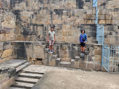 Two people standing on ancient stone steps.