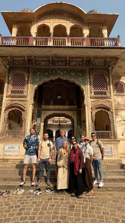 Group of people posing in front of a historical Indian building