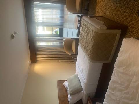       Hotel room with twin beds and a window view.
  